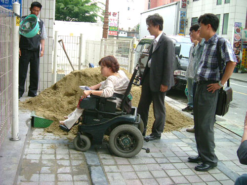직원용 엘리베이터 입구에 쌓인 모래가 기자회견에 참석하려는 박영희 장애인 이동권연대 공동대표를 가로막았다.