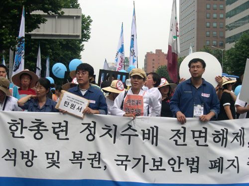 푸른색 수의를 입은 수배자와 가족들이 거리행진을 벌이고 있다. 찜통더위보다 이들의 심정이 더 타들어가는 듯하다.