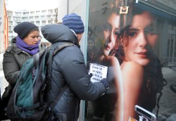 보정광고반대청년 활동가들이 포스터를 붙이고 있다.