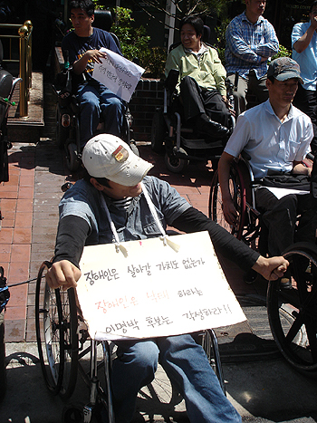 2007년 이명박 대통령 후보맴프에서 서울시장 시절 그가 장애인일 경우 낙태할 수도 있지 않냐고 발언해 장애인권활동가들이 이에 사과를 요구하고 있는 모습(사진 출처: 민중언론 참세상)