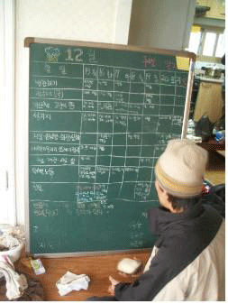 주번제. 할 일과 날짜, 일한 사람들 적어놓은 것을 주번이 확인하고 있다.<br />