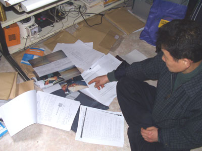 피해여성의 아버지 정현조 씨가 발로 뛰며 수집해온 사건 자료들을 펼쳐 보이고 있다.
