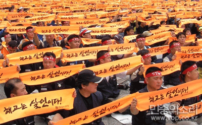 ‘해고는 살인이다’, 라는 손수건을 들고 구호를 외치는 모습 ( 사진 출처: 민중의 소리)