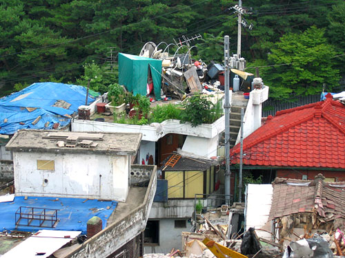 삼선 4구역의 살아있는 집들. 주위는 모두 철거되어 유령 같은 골목길과 건물의 잔해들이 가득하다.