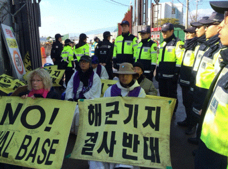 제주해군기지 공사장 앞에서 매일 열리는 강정의 평화를 위한 미사 중 경찰에게 고착된 사람들