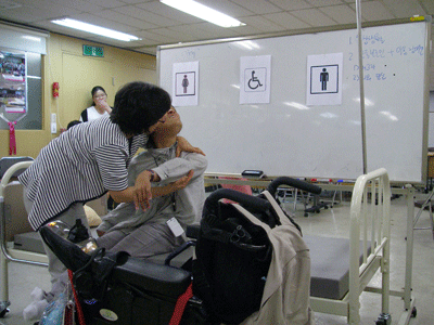 혼자서 은영 씨를 휠체어에 앉히려고 하지만 잘 안 된다. 
